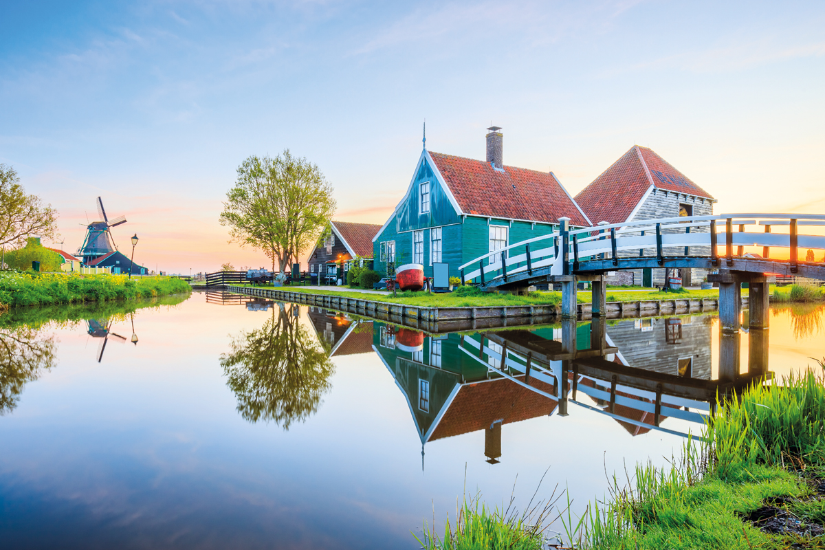 Zaanse Schans village, Netherlands. Dutch windmill and traditional house at sunrise.