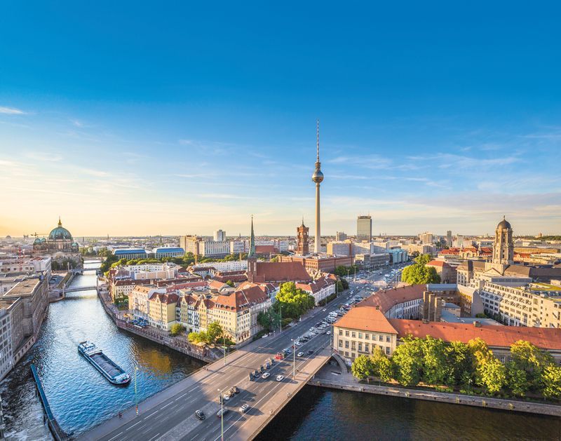 Berlin skyline panorama with TV tower and Spree river at sunset,